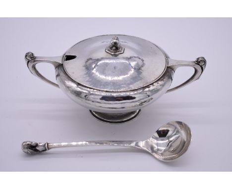 An Arts &amp; Crafts hammered white metal sauce tureen and ladle, having rabbit and pheasant finials, 19.5cm wide, 438g. 