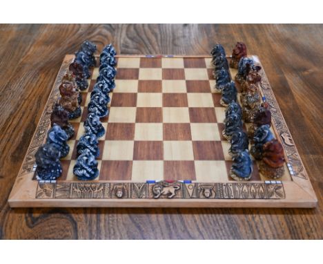 A Kumbula carved wood chessboard, the resin pieces depicting 'The Fat Five (Africa's Chubbiest Animals)' 