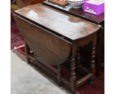 An antique oak drop leaf dining table with end drawer, turned gate-leg action base 