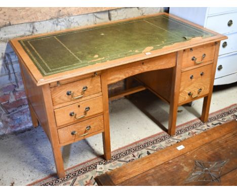 Early 20th century light oak kneehole five drawer drawer desk with green leather top a/f to/w an early 20th century swivel of