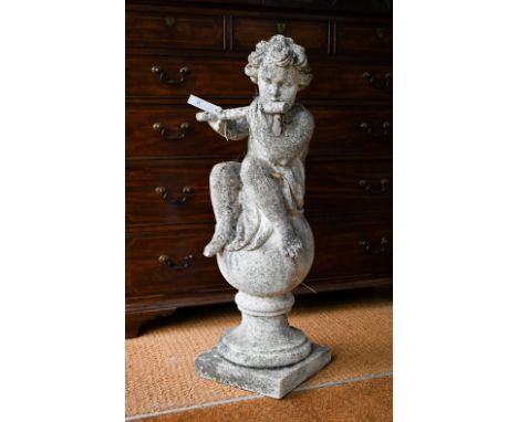 A weathered cast stone cherub playing a flute,&nbsp;seated on a ball, 100 cm h