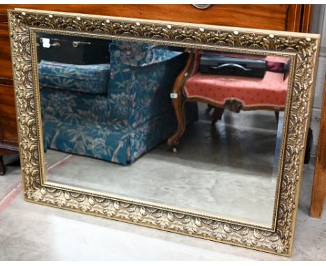A bevelled rectangular mirror in foliate gilt frame, 102 x 74 cm to/w arched overmantel in stained pine moulded frame, 114 cm