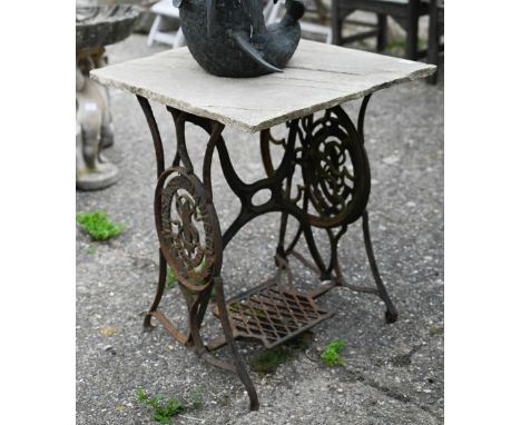 A vintage cast iron Singer sewing machine treadle base with stone slab table top 