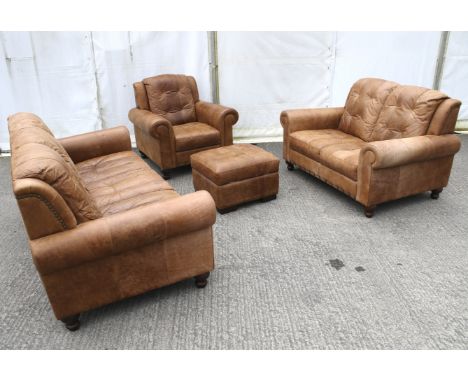 A destressed effect four piece loung suite comprising a Three seater sofa, armchair, two seater sofa all raised on mahogany t