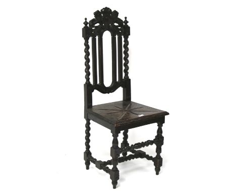 A carved wooden chair. The back featuring turned columns, finials, and topped by a pair of lions, raised on turned supports w