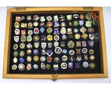 Approximately 100 vintage enamel badges. Within a wooden display cabinet