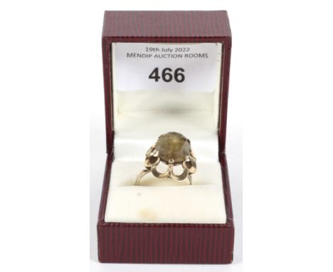 A 9ct gold ring. Stamped '9ct AL', with pierced U-shaped foliate setting around a pale brown coloured stone