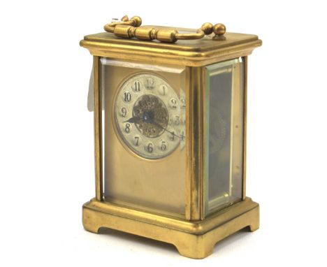 A brass carriage clock. The circular silvered dial with Arabic numerals, a carrying handle to the top, unknown maker, H11cm