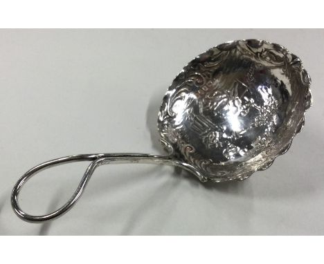 A large chased silver caddy spoon bearing import marks. London 1901. Approx. 18 grams. Est. £30 - £40.