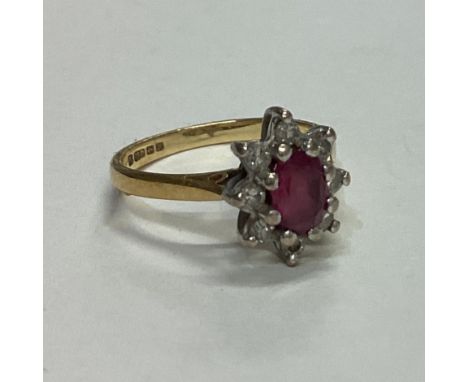 A ruby and diamond daisy head cluster ring set in 18 carat gold. Approx. 2 grams. Est. £60 - £80.