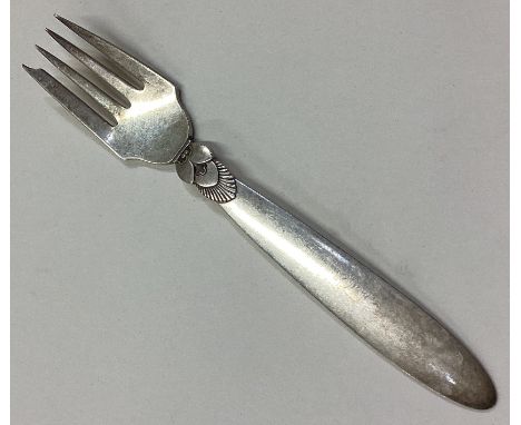 GEORG JENSEN: A small silver dessert fork of typical form. Approx. 40 grams. Est. £30 - £50.