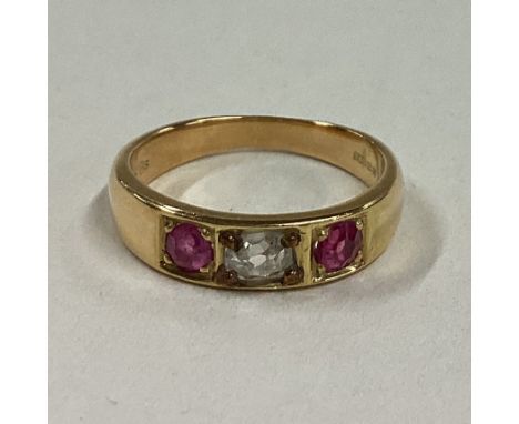 A diamond and ruby three stone gypsy set ring in 18 carat gold mount. Approx. 3 grams. Est. £80 - £120.