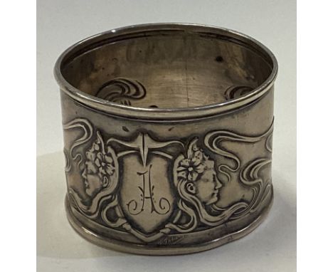 An Art Nouveau Continental silver napkin ring chased with faces and foliage. Approx. 24 grams. Est. £30 - £40.