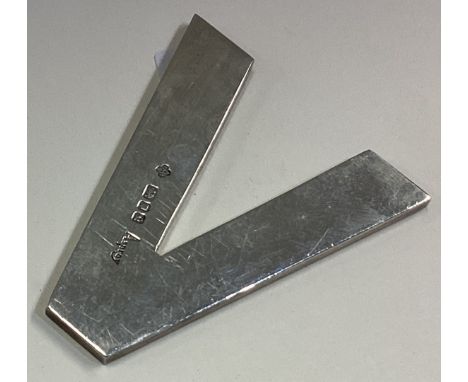 ASPREY: A heavy silver paperweight in the form of the letter 'V'. London 1990. Approx. 31 grams. Est. £30 - £40.