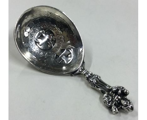 An Antique silver caddy spoon with figural handle and chased stag to centre. Approx. 40 grams. Est. £30 - £40.