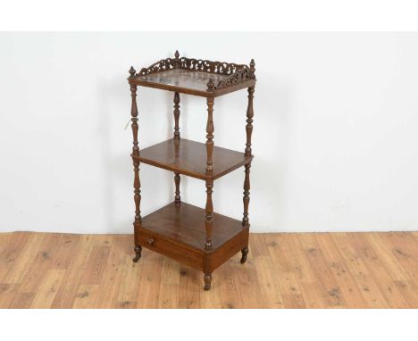 A Victorian mahogany three-tier whatnot, with pierced fretwork three-quarter galley to the top, turned baluster supports, sin