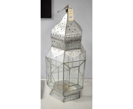 An Eastern glazed white metal lantern, of hexagonal form, 71cms high overall.