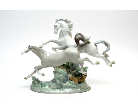 A Lladro decorative ceramic figure group of Horses Galloping, modelled on a naturalistic base, 30cms high.
