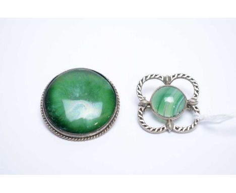A banded agate and silver brooch by John Hart, Iona, of quatrefoil design; and a ceramic cabochon (possibly Ruskin) and silve