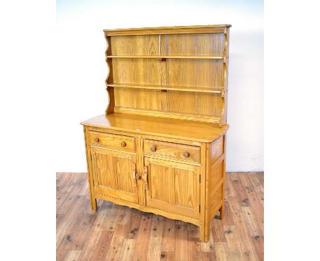 Ercol: a late 20th Century elm kitchen dresser, with a two-tiered waterfall plate rack, the lower section with a chamfered ed