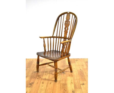 A 19th Century elm, ash and beech comb-back Windsor chair, the hooped backrest with pierced splat, saddle seat raised on turn