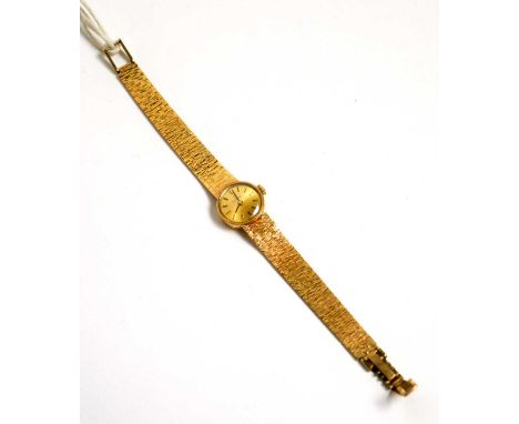 A 9ct yellow gold cocktail watch by Tissot, the gilt baton dial fitted manual wind movement, on bark pattern strap, 22.7g gro