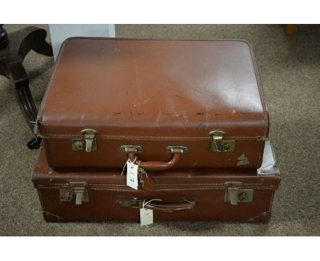 Two vintage brown travel trunks, one with brown leather RNLI fob, the largest 66cms wide.