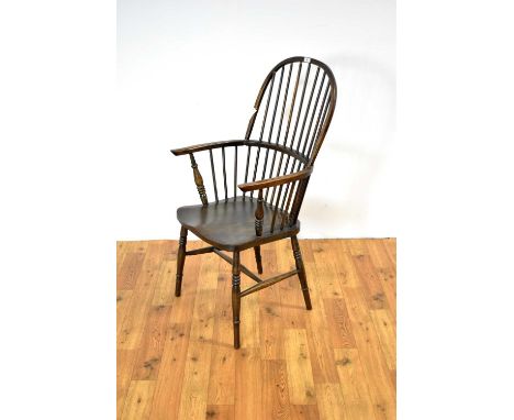 A 19th Century style beech and elm comb-back Windsor chair, the hooped backrest flanked by shaped elbow supports with a saddl