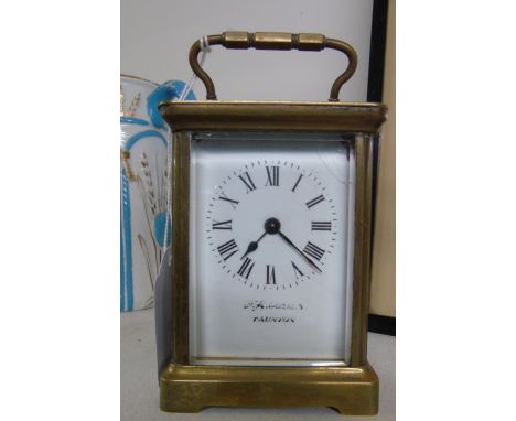 A French Brass Cased Carriage Clock; the white enamel dial with Roman numerals.