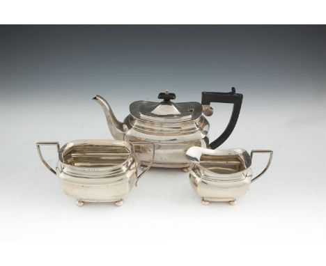 A GEORGE V SILVER THREE PIECE TEA SERVICE, Birmingham 1922/23, mark of J.G. Ltd., of shaped rectangular panelled form, raised