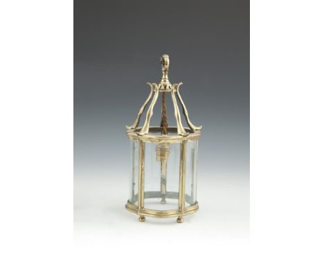A SMALL BRASS SHAPED CIRCULAR LANTERN with five curved clear glass panels and raised on ball feet. 33cm high, 16cm diameter