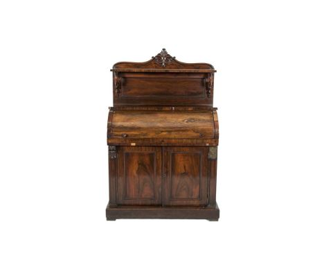 A VICTORIAN ROSEWOOD ROLL TOP WRITING CABINET with raised back above a cylinder desk with fitted interior above twin fielded 