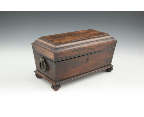 A REGENCY ROSEWOOD SARCOPHAGUS TEA CADDY, the flat domed hinged lid enclosing a zinc lined interior, the tapering case fitted