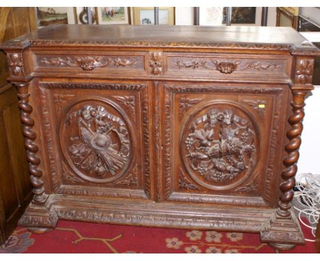 Late 19th century heavily carved oak sideboard with two drawers and mask handles over two doors with panels depicting farming