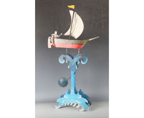 A 20th century polychrome painted metronomic automaton, modelled as a man sailing a boat on a shaped 'wave' stand, height 68c