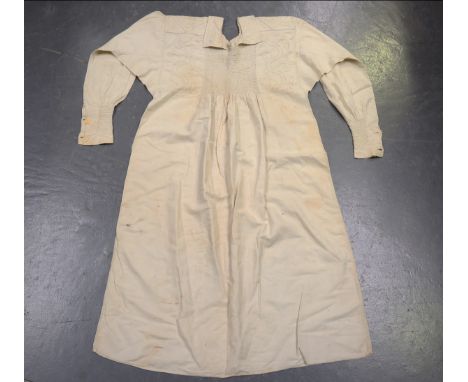 A quantity of early 20th century textiles, including a cream linen smock with foliate embroidery, length 123cm, a large croch
