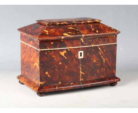 A Regency tortoiseshell twin-division tea caddy of bowfront sarcophagus form, raised on wooden bun feet, height 14cm, width 1