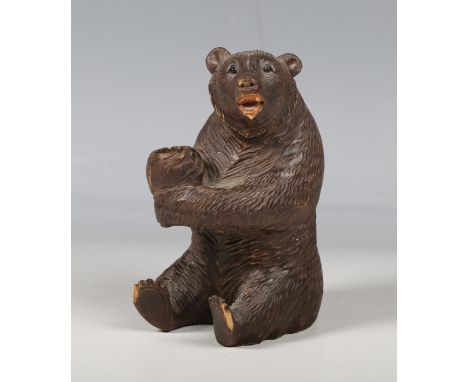 An early 20th century Black Forest softwood novelty pipe holder, carved as a seated bear, height 12cm.Buyer’s Premium 29.4% (