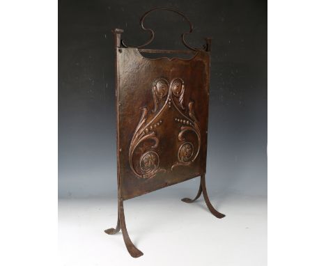 An Arts and Crafts copper and wrought iron framed firescreen, the shaped panel finely worked with flowerheads and scrolls, he