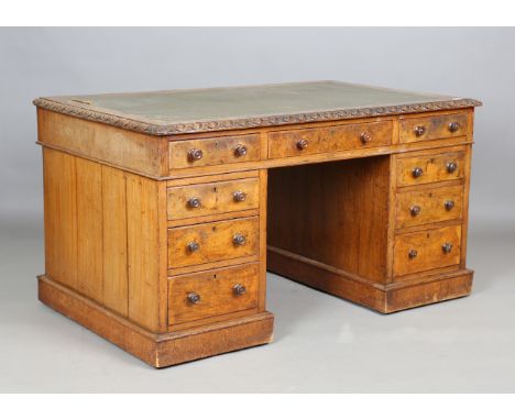 A mid-Victorian pollard oak twin pedestal desk, the top inset with leather and with a carved edge above an arrangement of dra