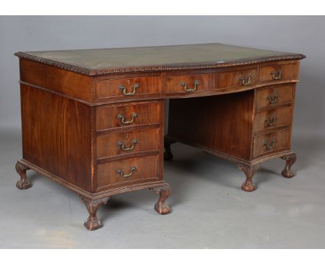 A George V mahogany twin pedestal desk by Wolfe &amp; Hollander, the serpentine front fitted with an arrangement of nine draw