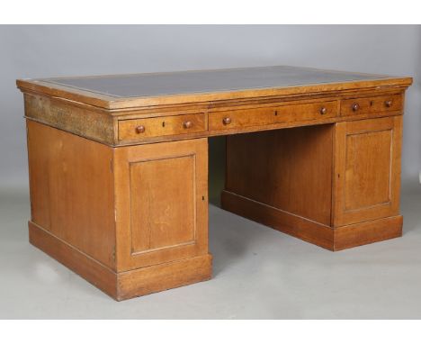 A Victorian pale oak twin pedestal partners desk, the top inset with gilt-tooled leather above a pull-out leather-inset slide