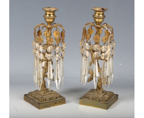 A pair of Regency gilt metal single-light table lustres, hung with cut glass drops, on a naturalistic tree stump support, hei