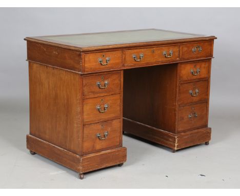 A small late Victorian walnut twin pedestal desk, the top inset with tooled green leather above an arrangement of nine drawer