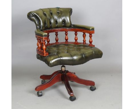 A late 20th century stained hardwood and buttoned green leather revolving tub back desk chair, height 86cm, width 64cm.Buyer’