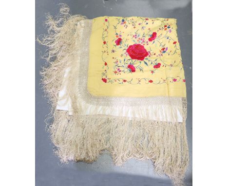 A Chinese silk shawl, embroidered in polychrome threads with peacocks and flowers, 117cm x 117cm, within a long cellular frin