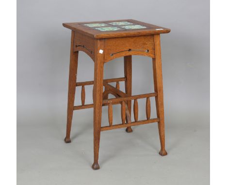 An Edwardian Arts and Crafts oak occasional table, probably by Liberty &amp; Co, the top inset with four ceramic tiles above 