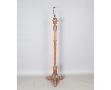 A George V walnut lamp standard, finely carved with acanthus leaf bands and sprays, the fluted column with triform base and t
