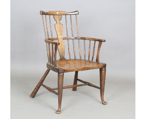 An early 20th century beech and elm stick back Windsor armchair by James Shoolbred &amp; Co Ltd, bearing label to underside, 