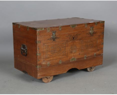 A 20th century Indian teak and brass inlaid dressing trunk, the hinged lid enclosing a compartmentalized interior, height 44c